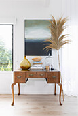 Antique desk, palm frond and landscape painting