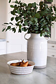 Bowl with pears and ceramic vase with eucalyptus branches
