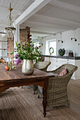 Rustic dining table with rattan chairs in open-plan interior