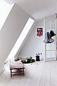 Brightly designed attic with bench and houseplants