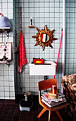 Retro-Badezimmer mit Fliesen, Holzstuhl und Spiegel in Sonnenform