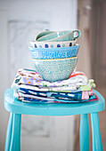 Stack of blue and turquoise bowls on painted stool