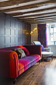 Opulent velvet sofa against panelled wall in living room