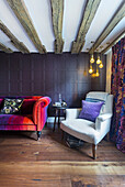 Opulent velvet sofa and armchair against panelled wall in living room