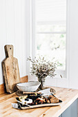 Cheese plate, bouquet of dried flowers and wooden board as rustic still life