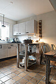 Vintage kitchen island on terracotta tiles in an open kitchen