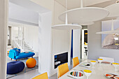 White dining room with colorful tableware, with a view into the living room and staircase