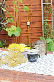 Marmeladenglas mit DIY-Deckel aus Birkenrinde und Blüten auf Tisch