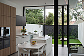 View from interior across dining and kitchen through glazing to rear courtyard garden