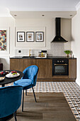 Dining area with blue upholstered chairs in front of small kitchen counter