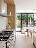 Kitchen counter with marble worktop and dining area in front of patio doors