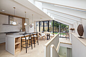 Kitchen with island counter and dining area in open-plan interior with skylights