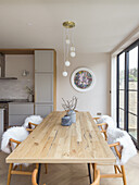 Classic chairs with animal fur around dining table with wooden top