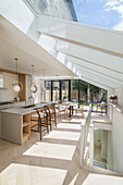 Kitchen with kitchen island and dining area in open plan room with roof glazing