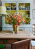 Herbststrauß aus Lampionblumen auf rustikalem Holztisch