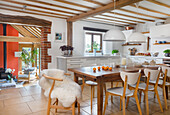 White eat-in kitchen with wooden dining table and classic chair in converted barn