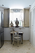 Desk in front of the window with folding shutters and Shabby Chic decoration