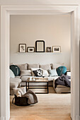 View into living room with sofa and cushions in beige tones
