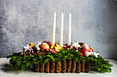 Christmas arrangement of pine cones, branches, fruits and candles