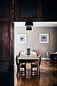 View of wooden table with chairs in dining room with rustic wooden floorboards