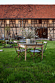 Rustic table and chairs with bouquet of cherry blossoms on table