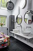Sessel mit Blumenstoff und Waschitsch mit Doppelwaschbecekn in Badezimmer