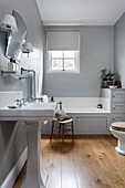 Standwaschbecken und Badewanne in einfachem Badezimmer mit grauen Wänden