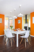 White table and chairs in dining area with orange walls