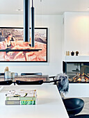 View over kitchen island to dining table and large photo on wall