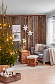 Weihnachtlich geschmücktes Wohnzimmer mit Tannenbaum, Geschenken, Holzwand und Sternen