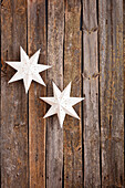 Paper stars on a rustic wooden wall as Christmas decorations