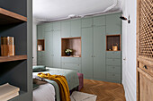 Built-in wardrobe in mint green with wooden elements in the bedroom