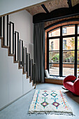 Modern staircase with metal banister and brick ceiling in loft apartment