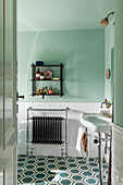 Bathroom with wall shelf, radiator and patterned floor tiles