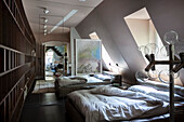 Floor lamp with glass globes, bed and large mirror in attic bedroom