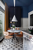 Dining area with pendant light, wooden chairs and blue walls