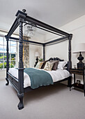 Four-poster bed with antique wooden frame in bedroom