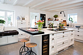 Kitchen island with a built in cooktop with breakfast bar in a white kitchen
