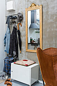 Wardrobe with metal locker and gold-framed mirror in one-room apartment