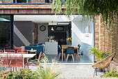 Tisch mit Stühlen auf Terrasse, Blick in offenen Wohnraum