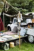 Liegestühle mit Kissen und Decken, beladener Geländewagen und Campingausrüstung