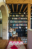 Reading corner with bookshelf and patterned armchair in rustic style