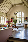 Bright living room with high ceilings, arched windows and vintage furniture