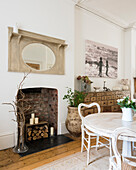Dining area in a shabby chic look with fireplace niche and apothecary drawers