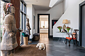 Hallway with warrior statues, sleeping dog; table and chair
