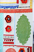 Screen decorated with doilies, trims, crochet flowers and pompoms