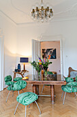 Esstisch aus Holz und Glas mit grün gemusterten Stühlen in klassischem Raum