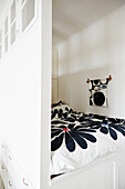 Sleeping alcove with single bed and black and white floral bed linen