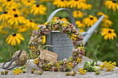 Late summer wreath made of sedum, tansy, blackberries, rose hips and hydrangeas on a wire ring
