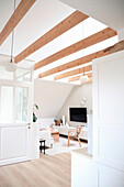 Bright living room with roof beams and minimalist furnishings